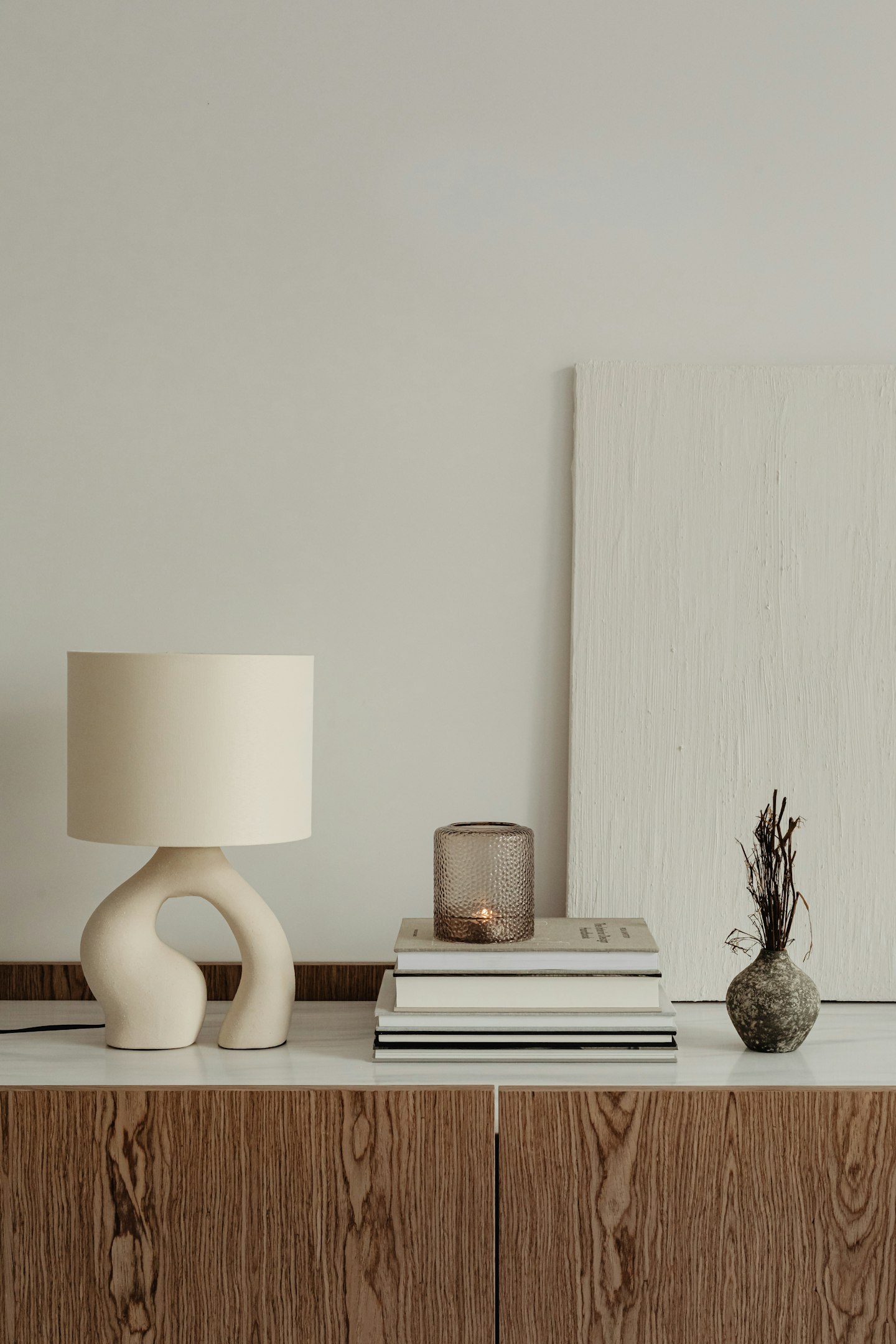 A ceramic lamp and books on a stone side table