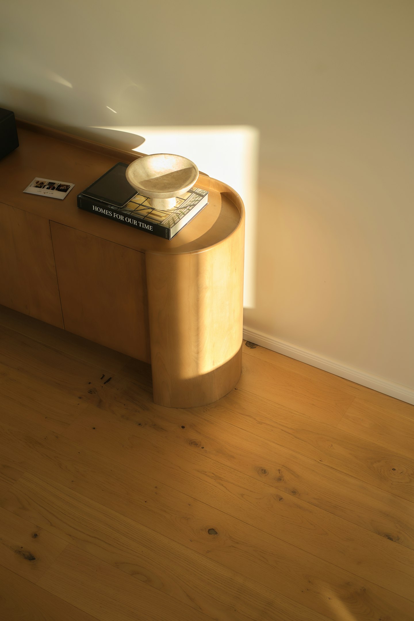 Warm sunlight falling across an oak cabinet and floor